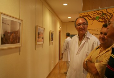 El Gerente del Departamento de Salud de Elda, Joan Lloret, y el presidente de Medicus Mundi Alicante, Diego Torrús, comentan con un trabajador del Hospital de Elda la exposición.