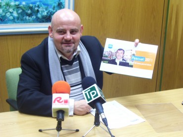 El secretario general del PP local, Fermín García, posa sonriente con un cartel promocional de su partido.