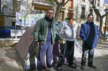 Tres vecinos se plantan en la Plaza de Baix para protestar por la situación de desempleo en el pueblo.